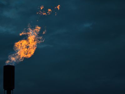 A Methane Flare Burns Against A Twilight Sky