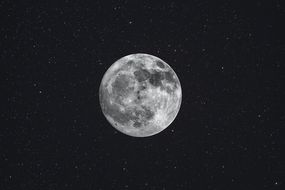 photo of moon at night, surrounded by stars