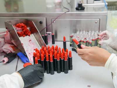 Cropped Hands Of People Making Lipstick In Factory