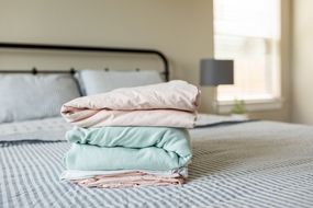 neatly folded bed sheets sit on top of made up bed in bedroom